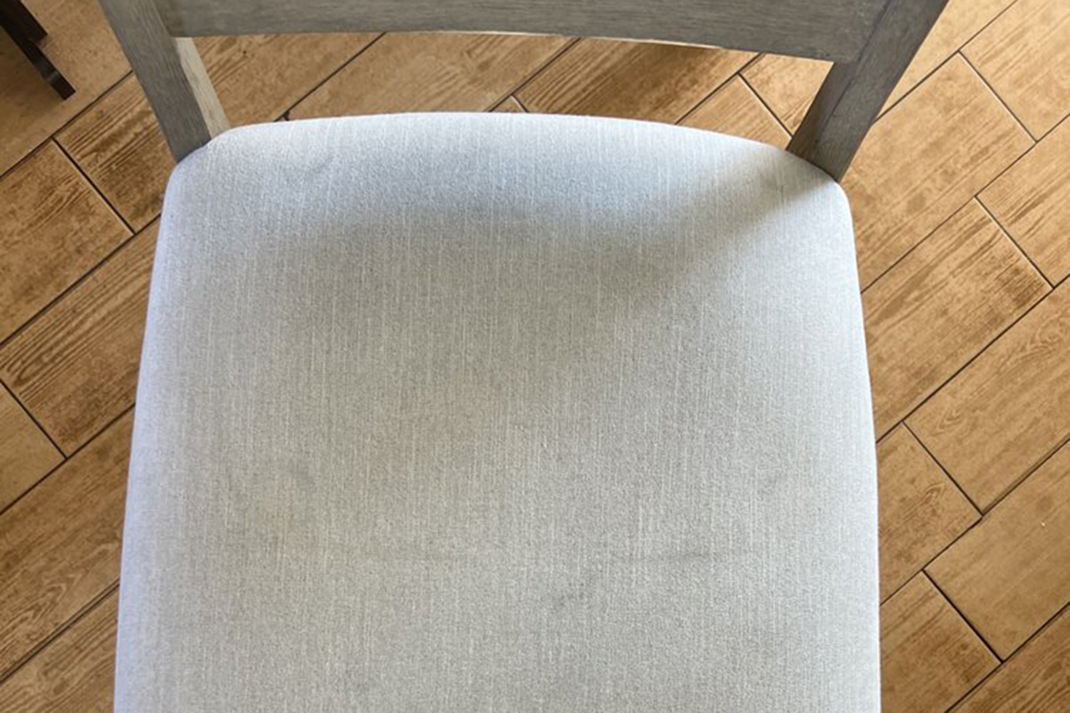 Restored beige upholstered chair after stain removal — fabric-safe furniture cleaning for dining chairs in Southern California.