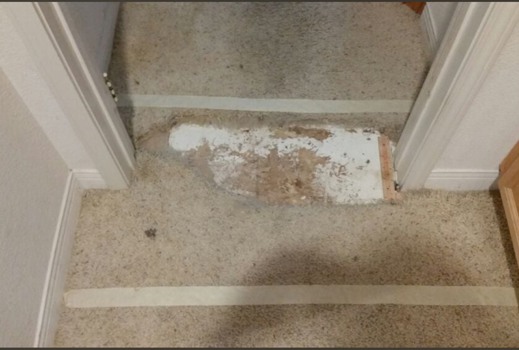 Damaged beige hallway carpet with exposed subfloor and padding removed—prior to professional carpet patch repair in Southern California.