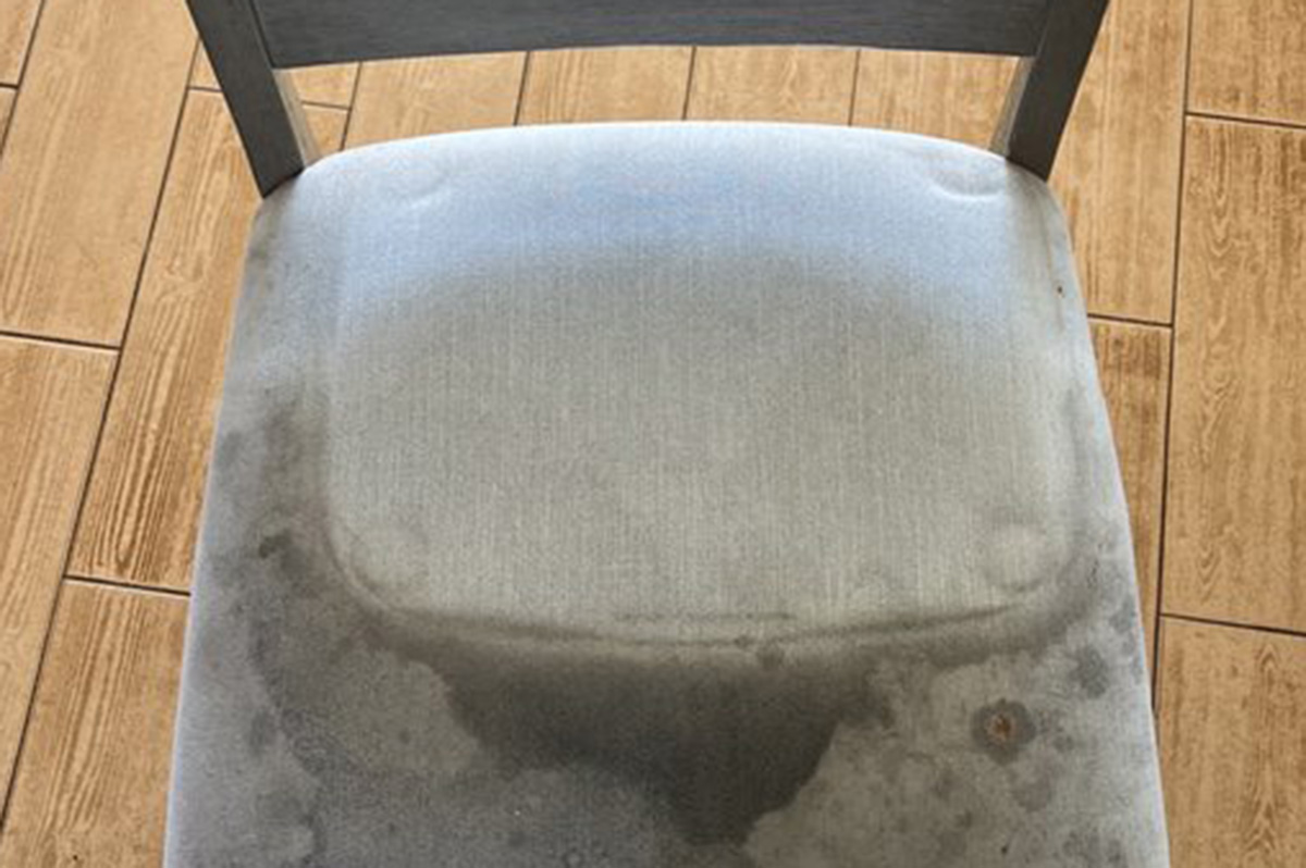 Severely stained dining chair before cleaning — advanced upholstery cleaning for high-use household furniture.