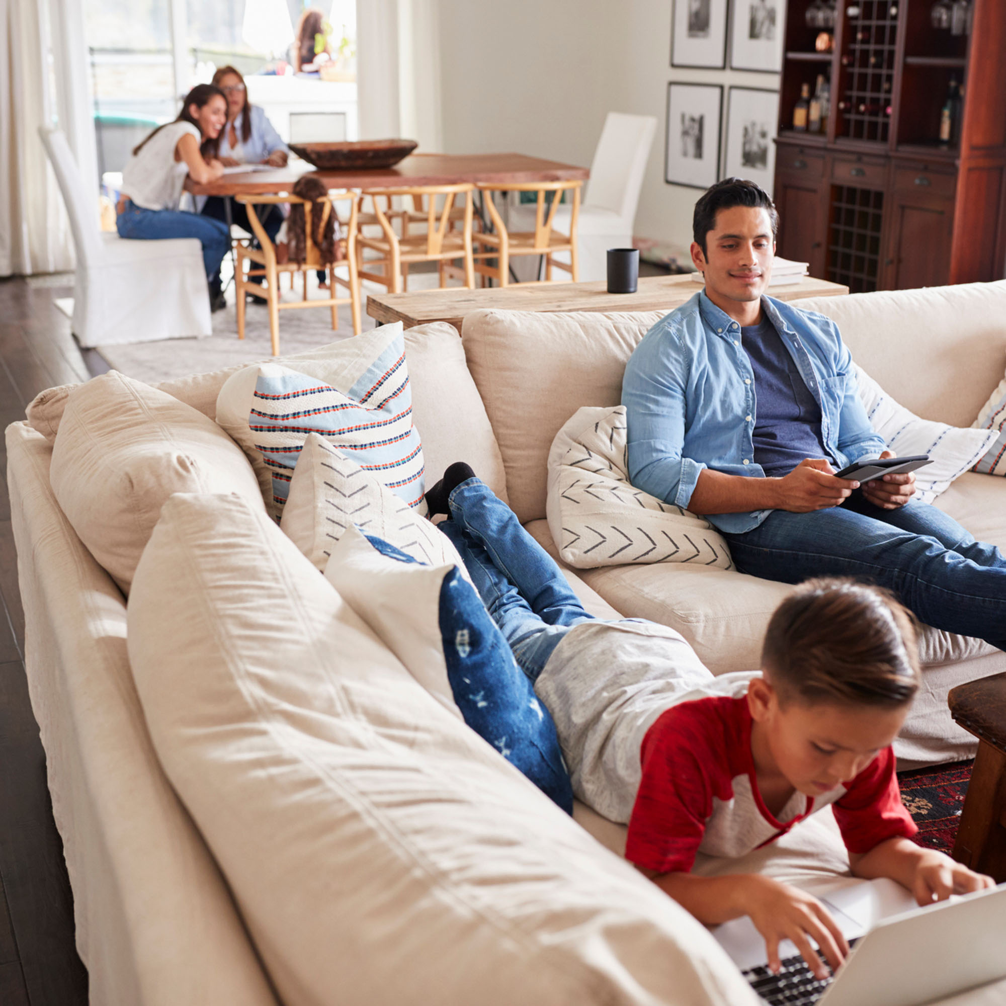 Modern family relaxing on a large sectional in a tidy home, representing Safer Choice Cleaning’s residential upholstery and carpet cleaning services.