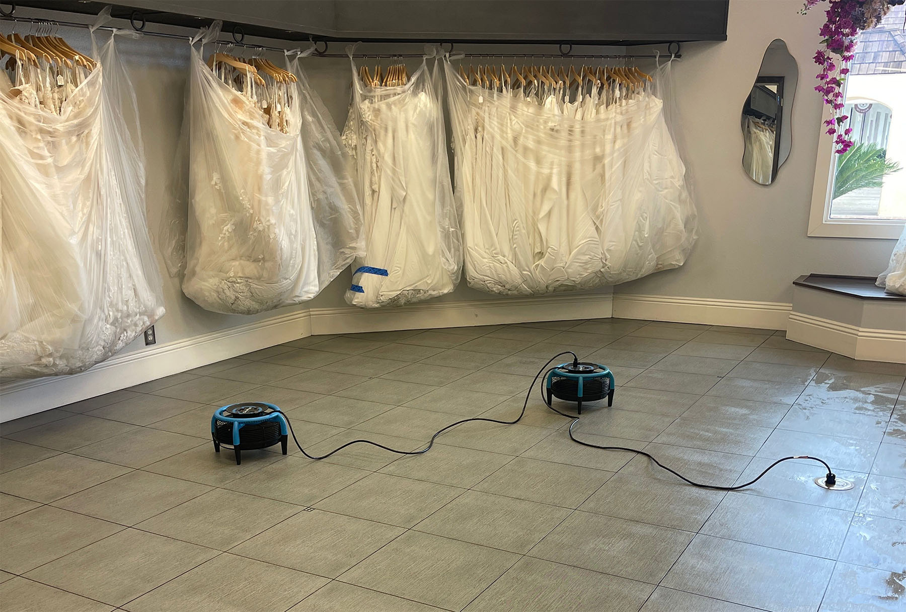 Bridal boutique showroom with dull tile floors and grout lines before professional commercial tile and grout cleaning by Safer Choice Cleaning.